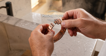 Removing a copper magnetic bracelet beside a bathroom sink before a shower