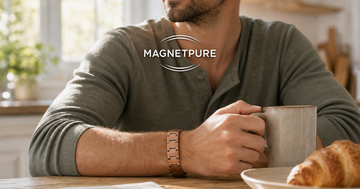 Man at a sunlit breakfast table wearing a copper magnetic bracelet with his morning coffee